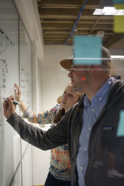 REGROUP team members writing on whiteboard