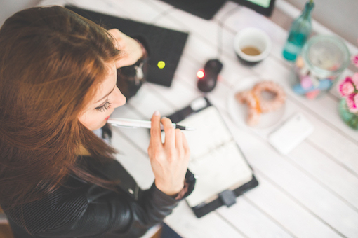 Woman chewing on pen at office