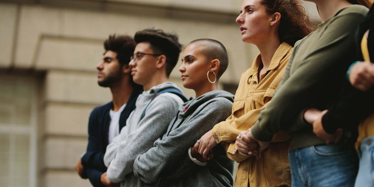 Group of young people linking arms