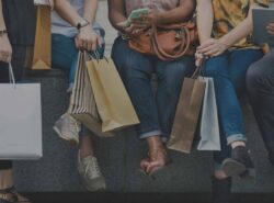 People sitting and holding shopping bags
